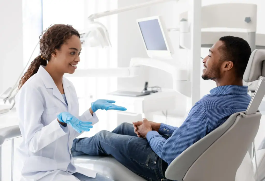 Dentista orientando paciente durante uma consulta de avaliação odontológica.